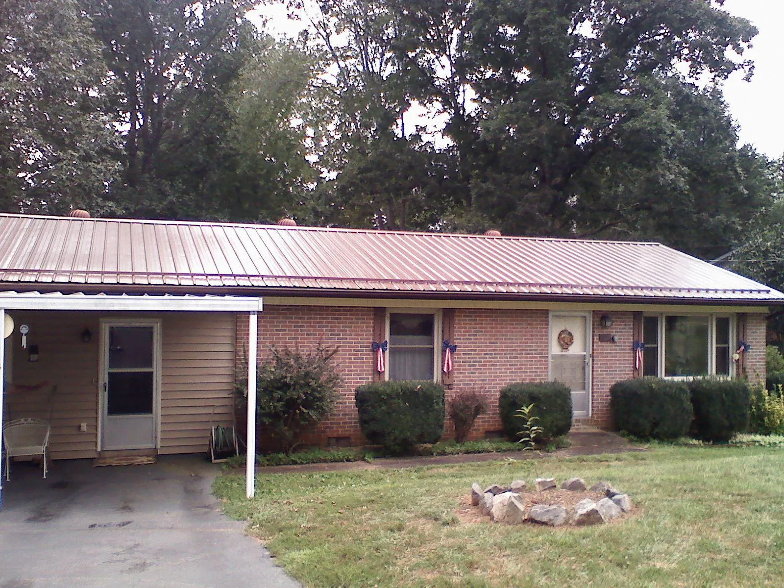 Bronze metal roof and carport on a brick ranch home — Roof Repair work by our crew in Fitzgerald